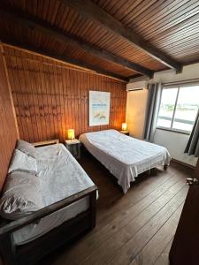 1 dormitorio con 2 camas y 2 lámparas. en Serendipia, en Maldonado