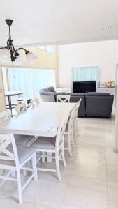 北谷町にあるCHATAN OCEAN Villaのリビングルームの白いテーブルと椅子