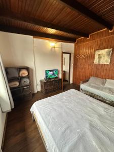 Un dormitorio con una cama y un televisor de pantalla plana. en Serendipia, en Maldonado