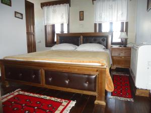a large bed with a wooden frame in a bedroom at Hotel Klea in Berat