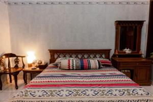 una camera da letto con un letto, un tavolo e uno specchio di Noah House a Yogyakarta