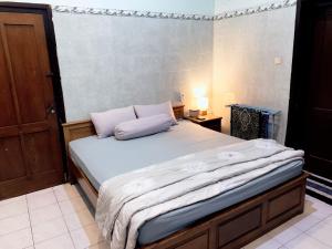 un letto con due cuscini sopra in una stanza di Noah House a Yogyakarta