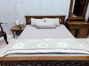 una camera con letto con struttura in legno e scrivania di Noah House a Yogyakarta