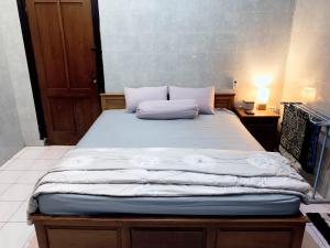 un letto con due cuscini sopra in una stanza di Noah House a Yogyakarta