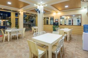 une salle à manger avec des tables et des chaises blanches dans l'établissement Villa Baldeo Resort, à Campo