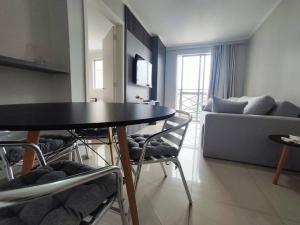 a living room with a table and chairs and a couch at Apartamento central in Passo Fundo