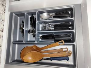 a drawer filled with utensils and a wooden spoon at Apartamento central in Passo Fundo