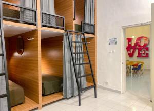 a bunk bed in a room with a ladder at Snooze Malang in Malang