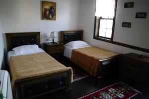 a bedroom with two beds and a window at Hotel Klea in Berat