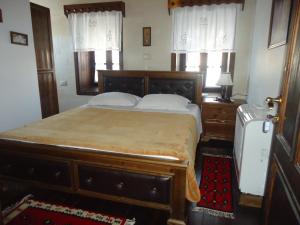 a bedroom with a large wooden bed with white pillows at Hotel Klea in Berat