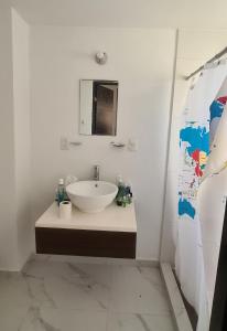 a white bathroom with a sink and a mirror at Departamento Moderno y Cómodo in Acapulco +5 photos