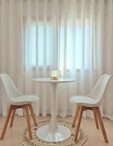 una mesa blanca con dos sillas y un reloj en ella en Happy Home Stay, en Seúl