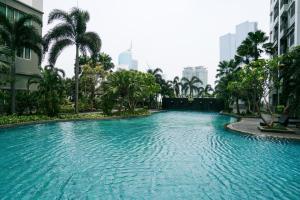 a swimming pool in the middle of a city at High Floor and Comfort Living 2BR Apartment at Thamrin Residence By Travelio in Jakarta