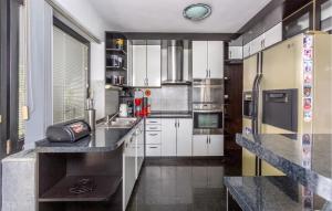 eine Küche mit weißen Schränken und schwarzen Arbeitsplatten in der Unterkunft Lovely Home In Bregi With Wifi in Breza