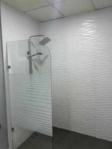 a shower with a glass door in a room at Hotel Hannabi in Boca Chica