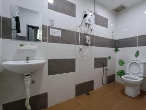 a bathroom with a sink and a toilet at Al Funduq Motel in Jitra