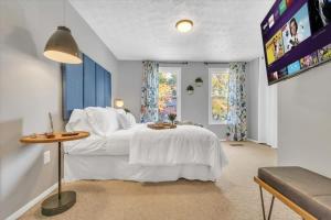 a bedroom with a large white bed and a tv at Renovated townhome on bike path includes bikes in Decatur