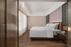 Llit o llits en una habitació de Mehood Lestie Hotel Dongguan Chang'an
