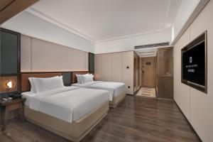 Llit o llits en una habitació de Mehood Lestie Hotel Dongguan Chang'an