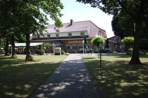 a walkway in front of a brick building with trees at Hotel-Restaurant Haus Waldesruh in Borken