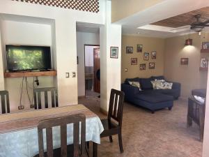 a living room with a blue couch and a tv at Beach house between Tamarindo and Avellanas in Santa Cruz
