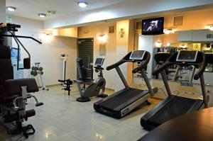 a gym with treadmills and exercise bikes in a room at Larsa Hotel in Amman