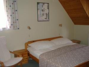 A bed or beds in a room at Hársfa Szálló