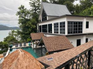 a house with a swimming pool next to the water at Villa Tranquility - Ultimate Estate in Ban Bang Bao