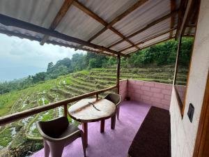 a balcony with a table and chairs and a view of a hill at Kingdom of Rustic Ella in Ella