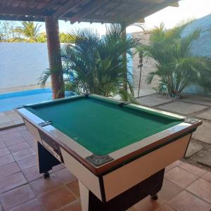 a pool table sitting on a patio next to a swimming pool at Casa Flor Morena in Aracati