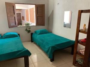 a room with two beds and two windows at Casa Flor Morena in Aracati +13 photos