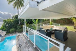 an outdoor patio with a pool and an umbrella at Domaine To'a Hotu in Tohautu