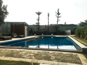 a large swimming pool in a yard with a fence at Sweet Home & Rooms East Asia 17, Greenlake City in Pondokpucung