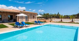 a swimming pool with blue chairs and a house at Ferienhaus Son Pieres Nou in Llucmajor