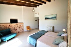 a bedroom with a bed and a couch and a television at Ferienhaus Son Pieres Nou in Llucmajor