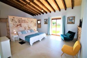 a bedroom with a bed and a chair and a window at Ferienhaus Son Pieres Nou in Llucmajor