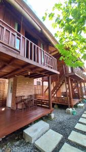a wooden deck of a house with a table and chairs at Sandyakala Borobudur in Magelang +21 photos