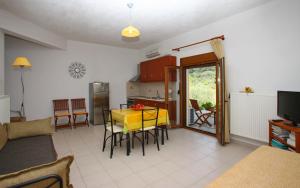 a living room with a table and a kitchen at Remvi Apartments in Skopelos Town