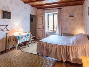 a bedroom with a bed and a table and a window at Chambres Confortables avec Petit Déjeuner Inclus et Salon de Jardin - FR-1-583-284 in Melin