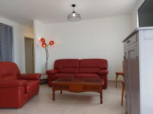 ein Wohnzimmer mit zwei roten Sofas und einem Couchtisch in der Unterkunft Maison familiale au calme avec jardin et barbecue - FR-1-581-144 in Saumeray