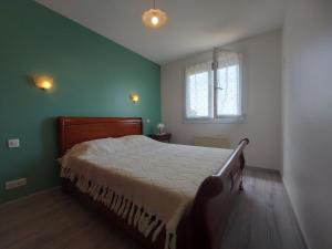 Schlafzimmer mit einem Bett mit grünen Wänden und einem Fenster in der Unterkunft Maison familiale au calme avec jardin et barbecue - FR-1-581-144 in Saumeray