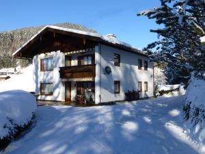 a large white house with snow on the ground at Ferienwohnung Haus Bergrast in Berchtesgaden