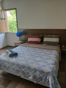 a bedroom with a bed with a blue comforter at Casa 4 quartos em Guarajuba, excelente localização! 200m da praia! in Camacari