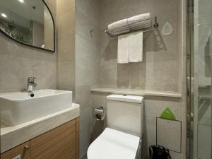 a bathroom with a white toilet and a sink at Hotel YX Lai Chi Kok in Hong Kong