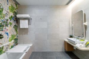 a bathroom with a tub and a sink at Hotel YX Lai Chi Kok in Hong Kong