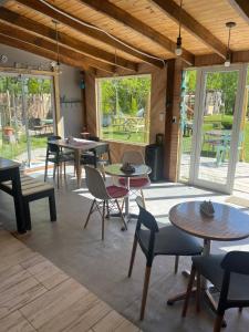 una habitación con mesas, sillas y ventanas en Camping Los Cardones, en Gobernador Gregores