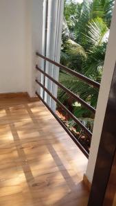 Una escalera en una habitación con suelo de madera y una ventana. en Yogiraj HomeStay - Tarkarli-Malvan, en Malvan