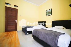 Postel nebo postele na pokoji v ubytování Surabaya Jaya Hotel near Soekarno Hatta Airport Redpartner + 37 fotografií