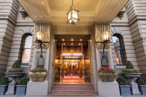 un vestíbulo de un hotel con dos macetas en The Hotel Windsor, en Melbourne