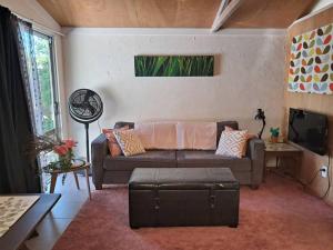 a living room with a couch and a tv at Manukorihi Sweet Guesthouse in Waitara